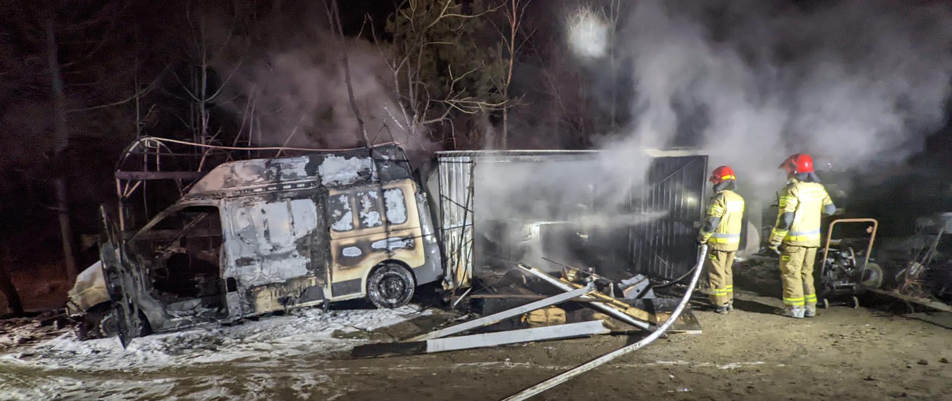 Strażacy gaszą pożar. Na zdjęciu widoczny jest spalony samochód dostawczy.