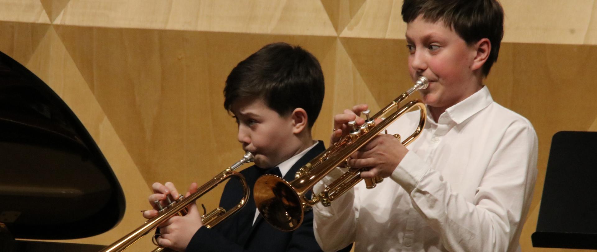 Dwóch trębaczy uczniów na scenie sali koncertowej psm