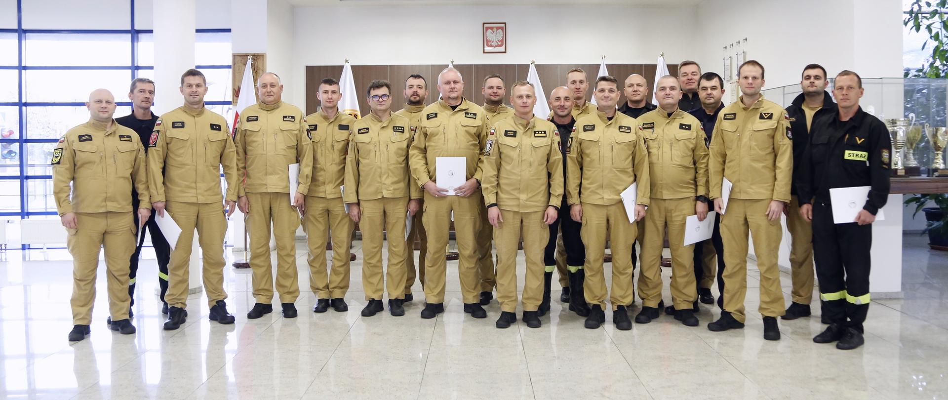 Grupowe zdjęcie funkcjonariuszy PSP będących uczestnikami szkolenia (20 osób) w towarzystwie Zastępcy Komendanta Centralnej Szkoły PSP