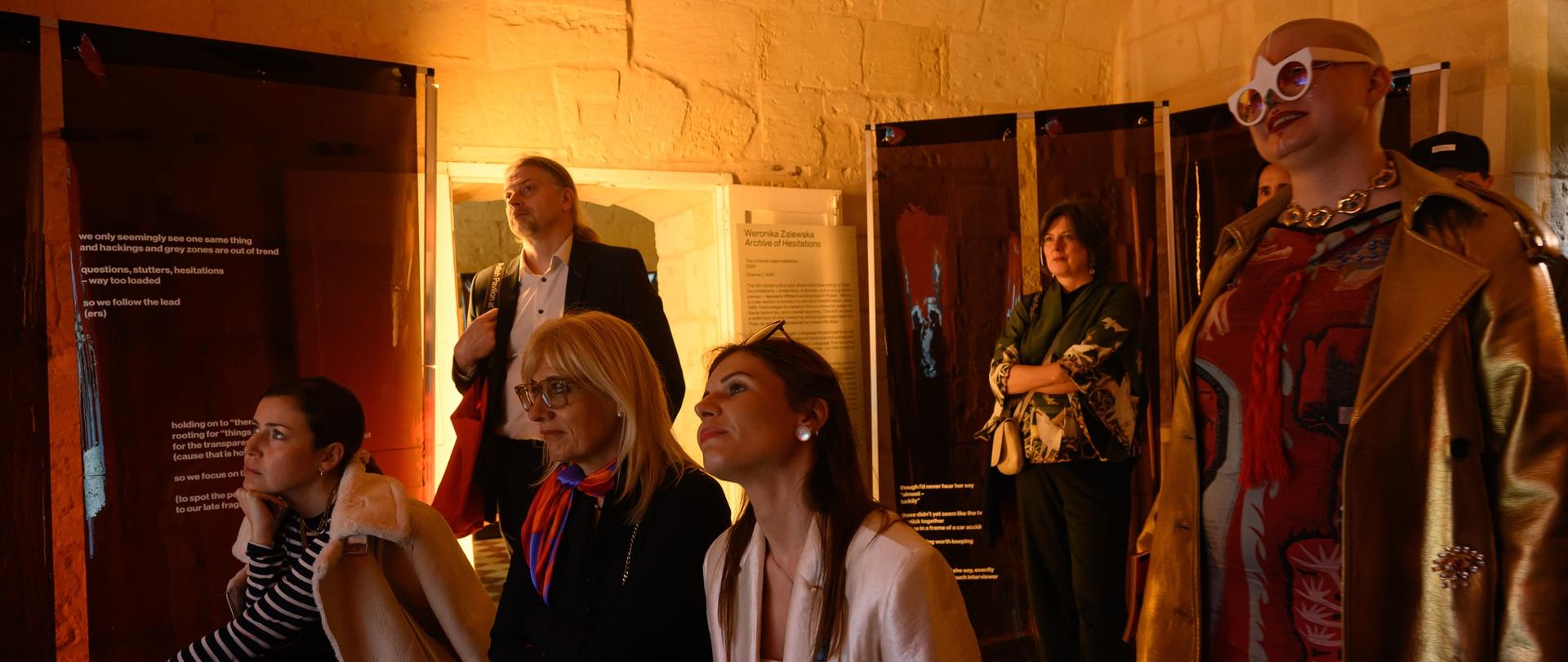 Grupa kobiet ogląda film wyświetlany w polskim pawilonie podczas Malta Art Biennale.