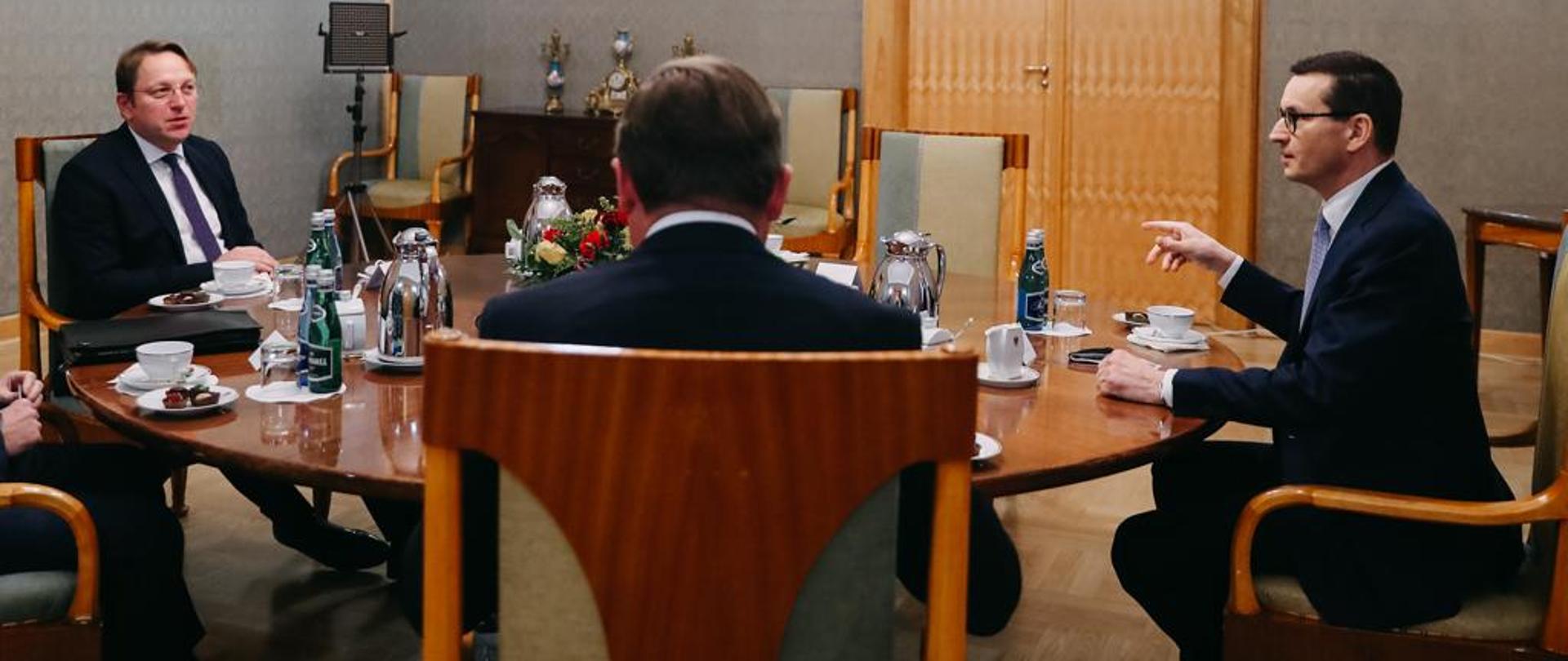 Spotkanie przy stole premiera z komisarzem UE ds. sąsiedztwa i rozszerzenia.
