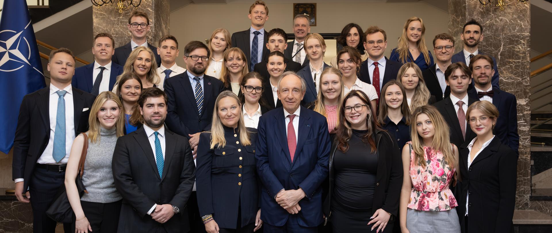 The photo shows a large group of participants at a meeting with Deputy Minister Władysław Teofil Bartoszewski. The photo was taken on the stairs. 