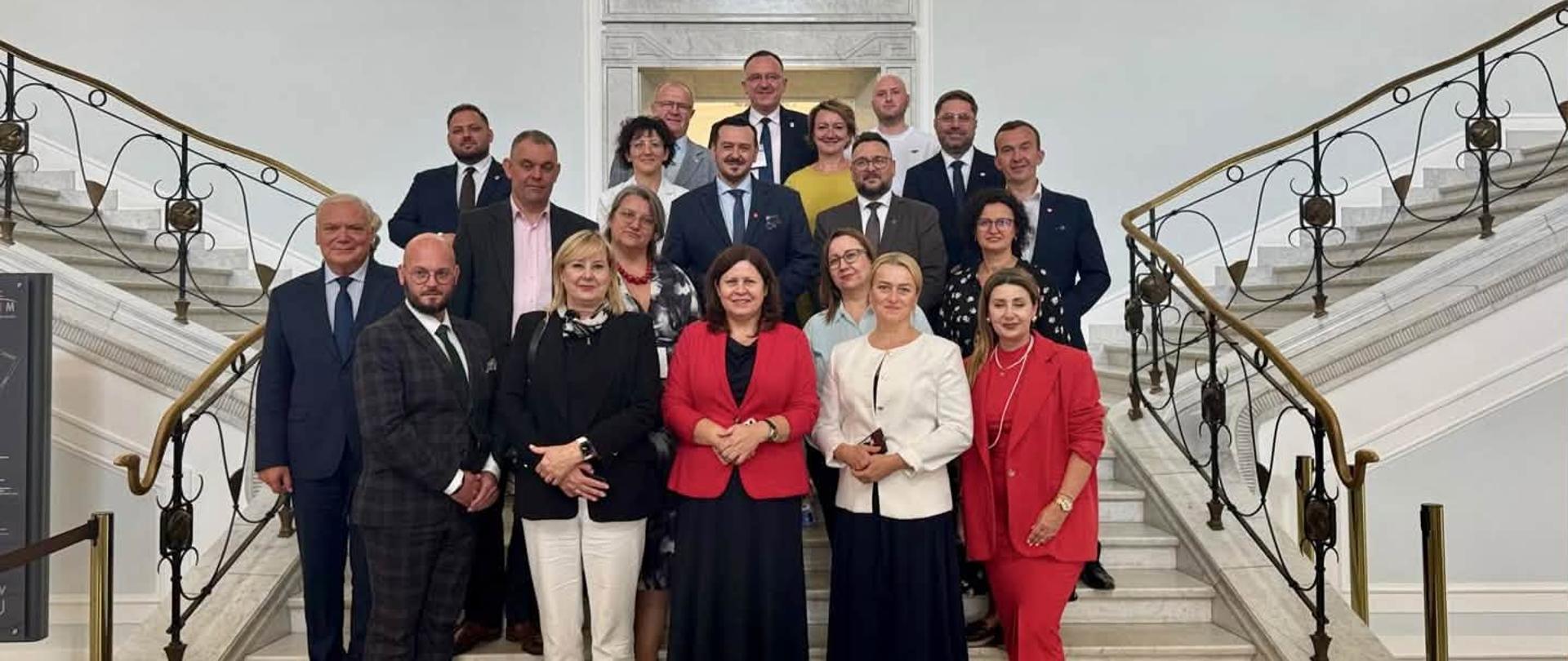 Grupa kilkunastu osób stoi na schodach 