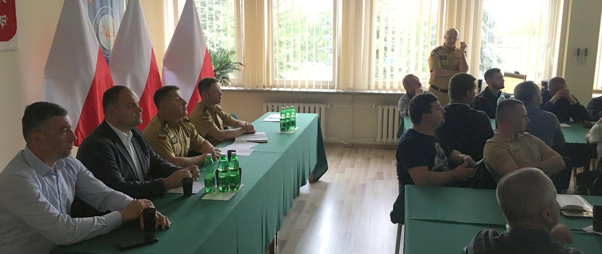 Na zdjęciu widoczna sala szkoleniowa KM PSP. Widzimy również przedstawicieli władz samorządowych oraz Komendantów KM PSP w Tarnowie. Widoczne są również osoby biorące udział w spotkaniu w związku z organizacją 3 Igrzysk Europejskich 2023.