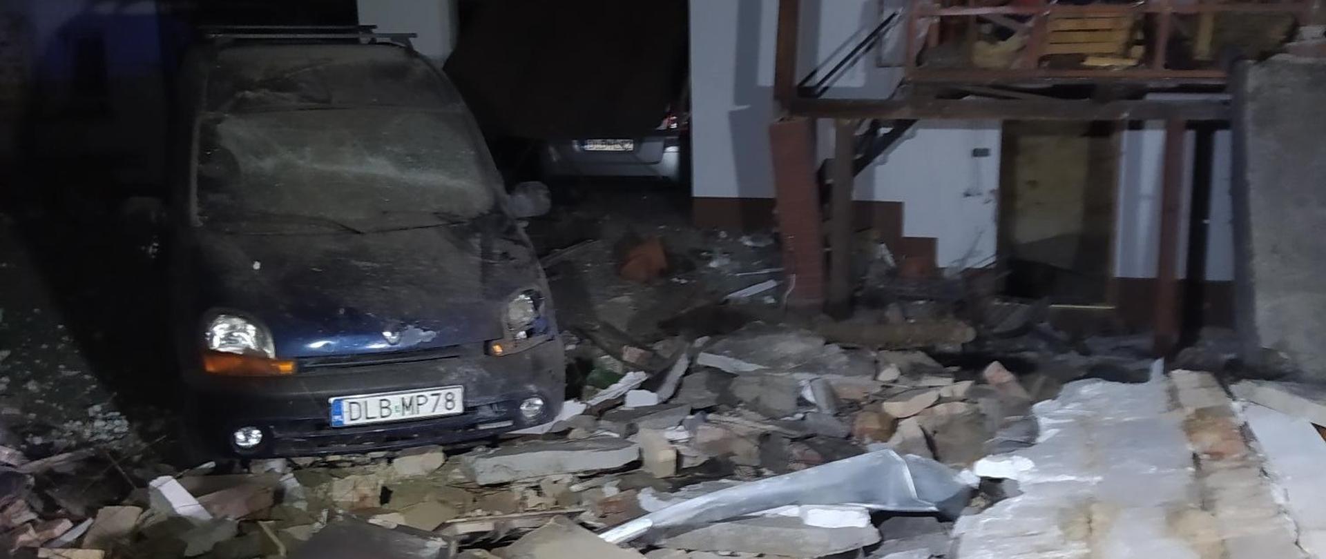 Samochód osobowy na tle gruzów