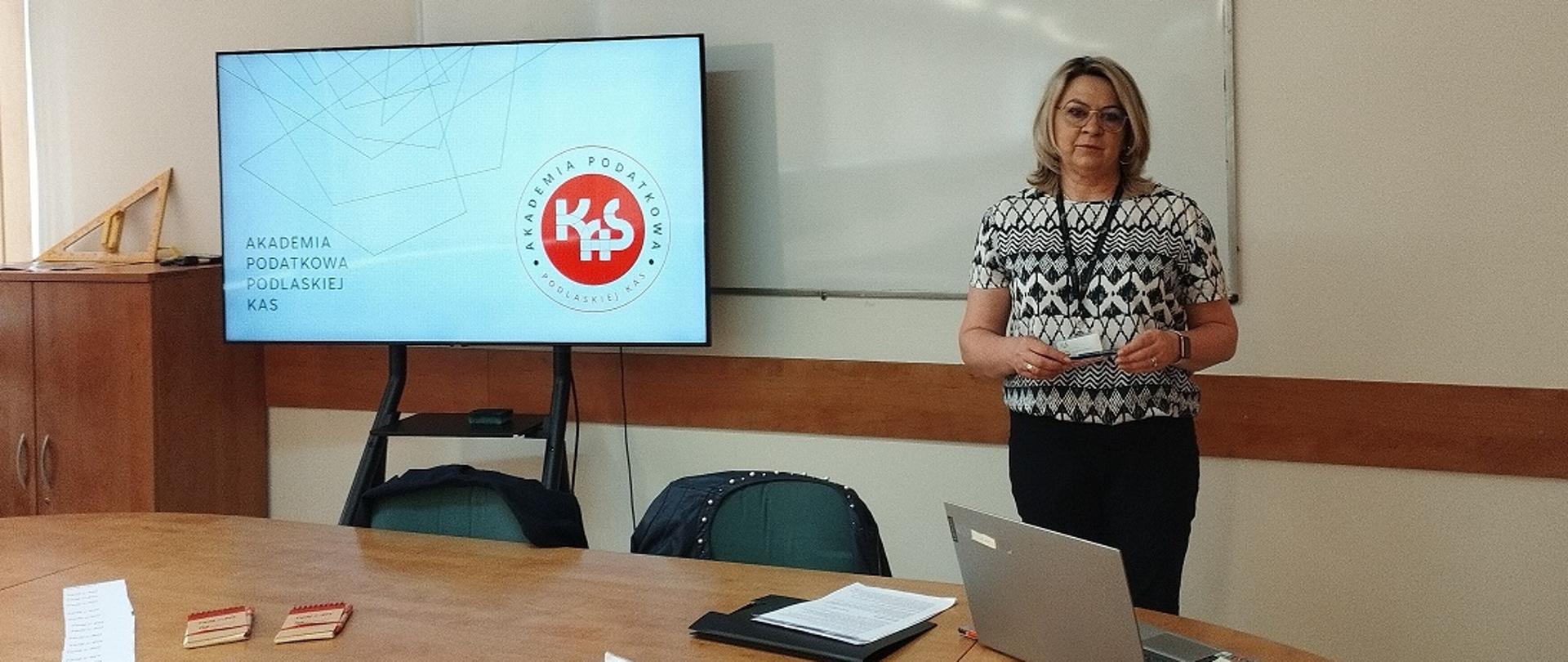 Edukator Akademii Podatkowej Podlaskiej KAS prowadzi lekcję o podatkach w szkole ponadpodstawowej