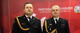 Na zdjęciu znajdują się przechodzący na zaopatrzenie emerytalne oraz Komendant Powiatowy na tle ścinaki z napisem Państwowa Straż Pożarna.