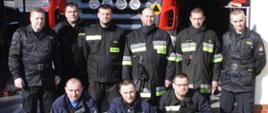 Zdjęcie przedstawia strażaków ochotników przed samochodem pożarniczym