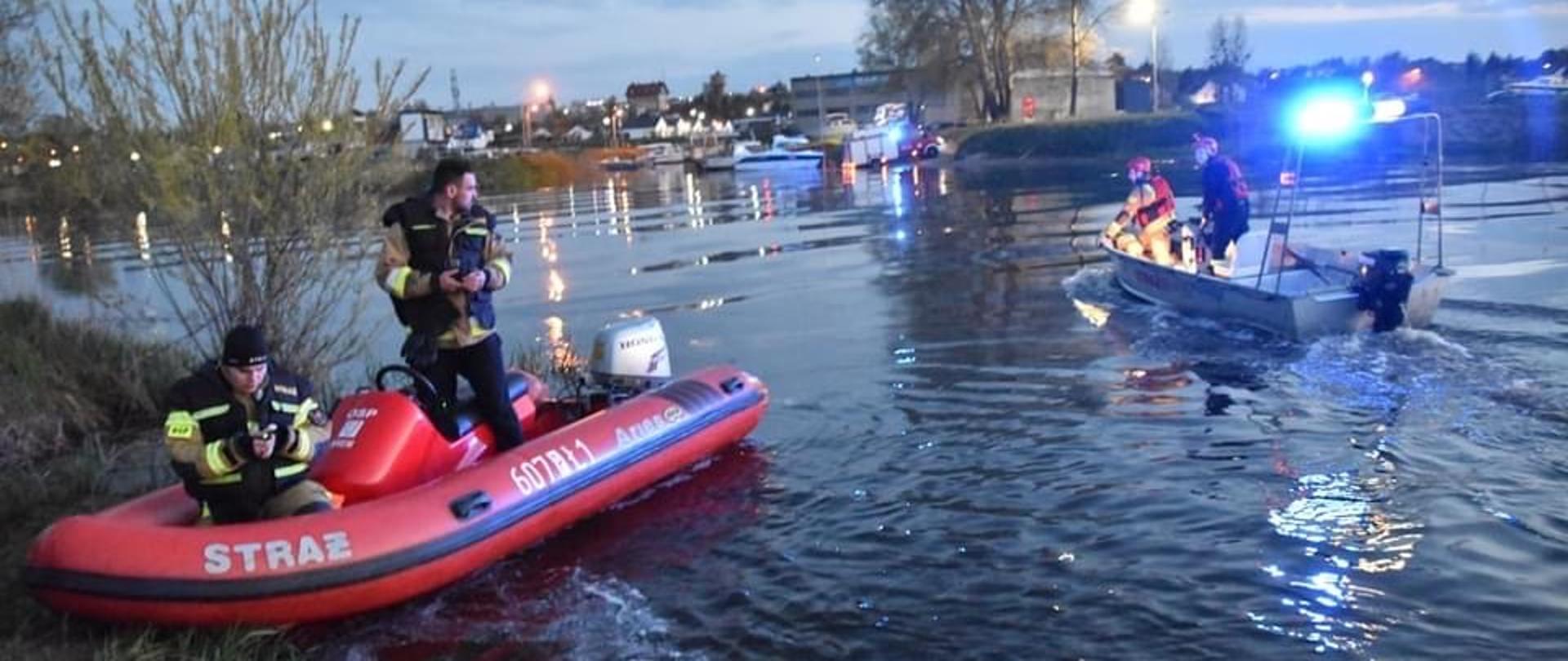 na zdjęciu rzeka warta na brzegu ponton na rzece płynąca Łódź ze strażakami 