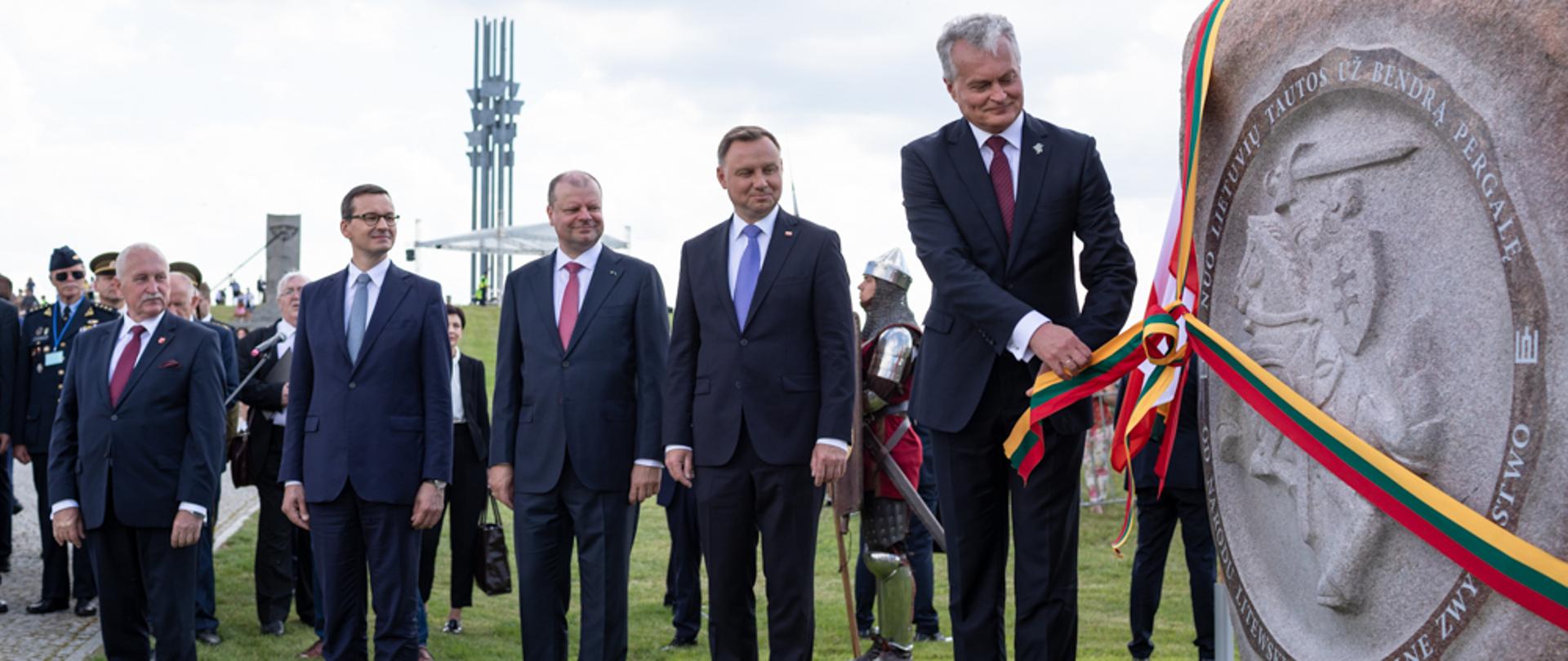 Od lewej: premier Mateusz Morawiecki, Saulius Skvernelis, prezydent Andrzej Duda oraz Gitanas Nausėda stoją przy odsłoniętym kamieniu.