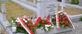 Nagrobek żołnierzy wojska polskiego poległych we wrześniu 1939 roku pod którym stoją znicze oraz wieńce z biało-czerwonych róż