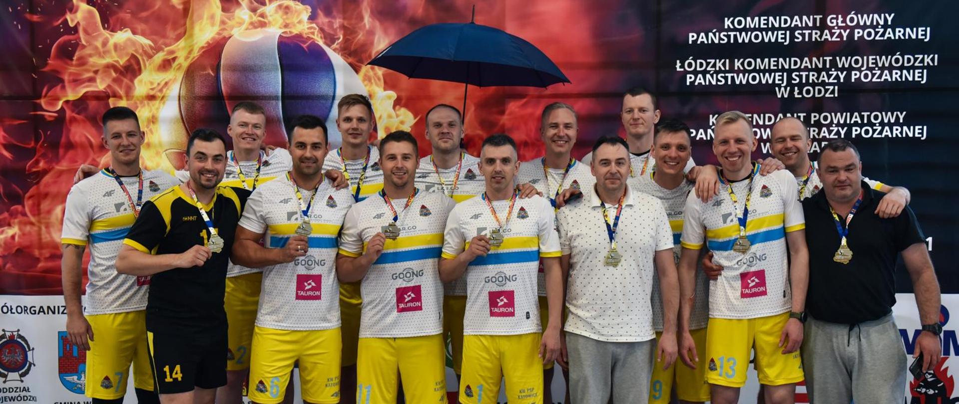 zwycięska drużyna pozuje do zdjęcia z medalami i pucharem