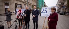 Minister Buda, minister Szynkowski i poseł Emilewicz stoją na poznańskiej ulicy i mówią do mikrofonów mediów