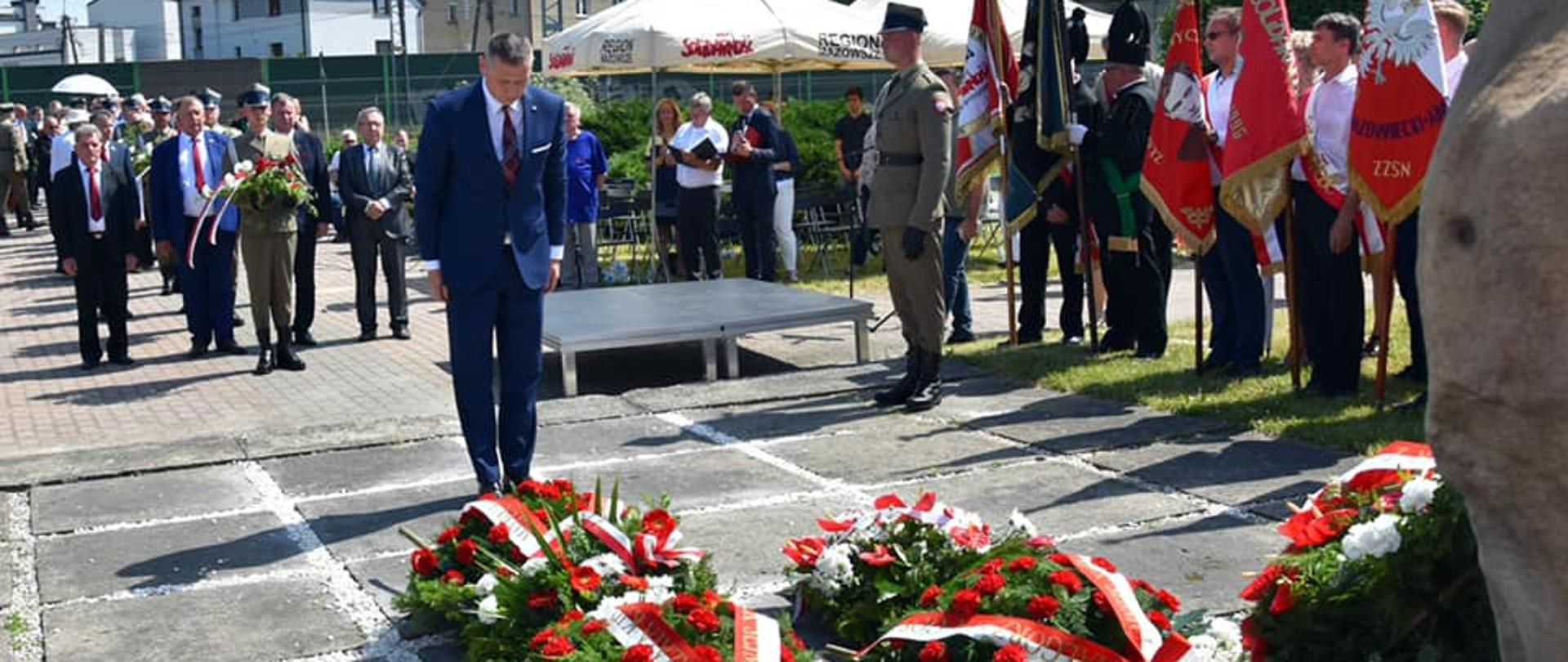 Na zdjęciu znajduje się mężczyzna, których składa pokłon przed pomnikiem