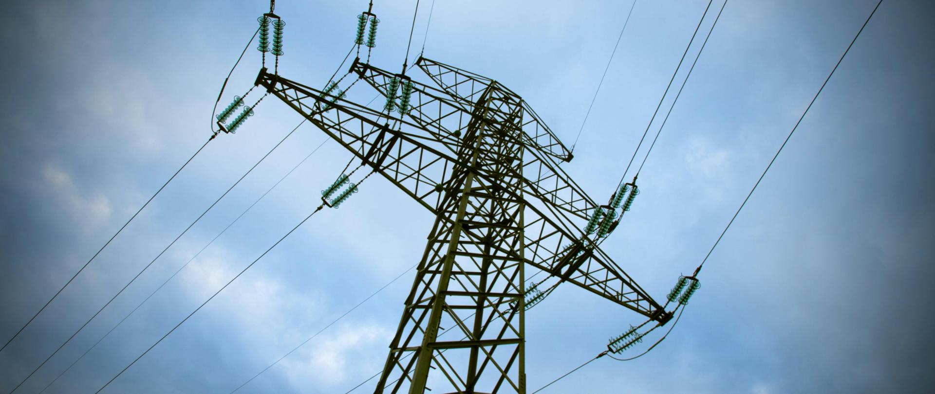 na zdjęciu wieża energetyczna na tle niebieskiego nieba