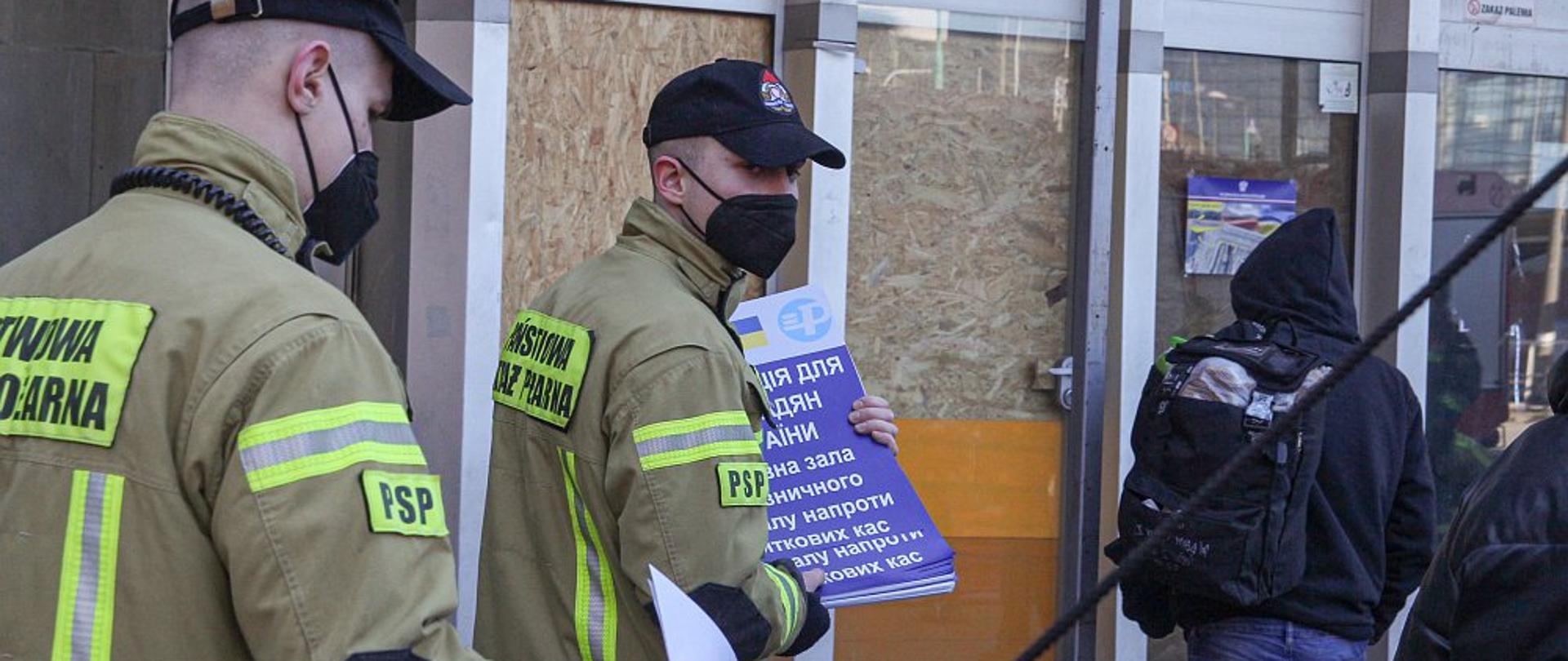 strażacy roznoszący ulotki