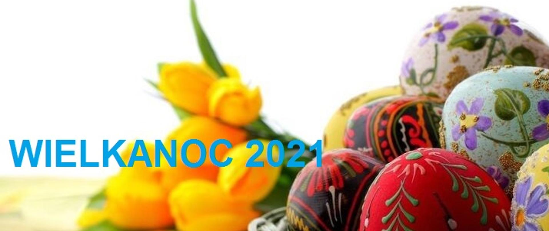 Kolorowa fotografia przedstawia kilka malowanych, wielokolorowych jajek w koszyku, na tle bukietu żółtych tulipanów z niebieskim napisem obok Wielkanoc 2021.