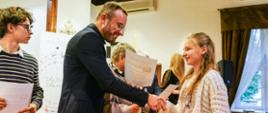 Dariusz Przybylski wręcza dyplom za uczestnictwo uczennicy Jadwigi Radke.