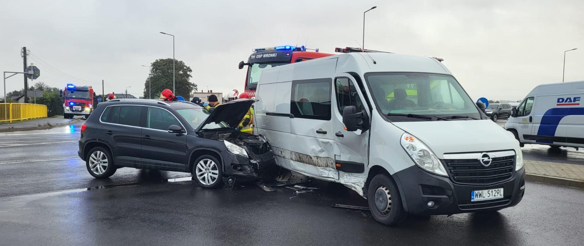 Ciemny samochód uderzył w bok białego pojazdu, są uszkodzone