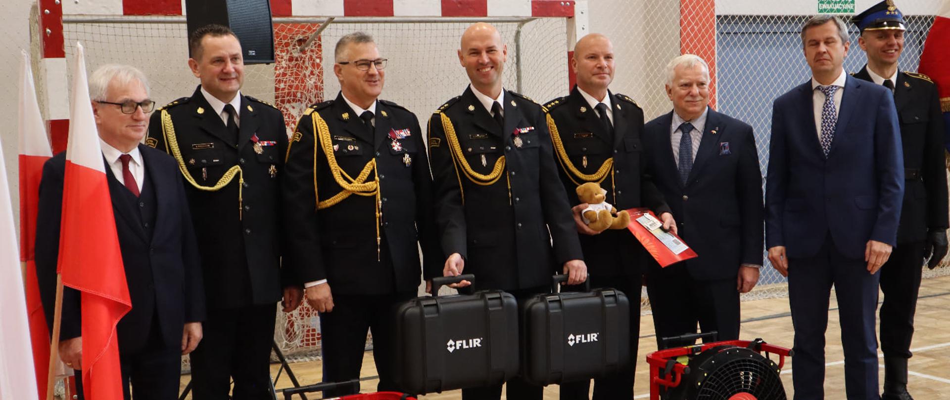 Przekazanie sprzętu dla KM PSP w Toruniu. Od lewej: flaga państwowa, Starosta Toruński Pan Marek Olszewski, Komendant iejski PSP w Toruniu st. bryg. Sławomir Reszkowski, Kujawsko-Pomorski Komendant Wojewódzki nadbryg. Jacek Kaczmarek, Zastępca Komendanta Miejskiego PSP w Toruniu bryg. Sławomir Grudziński, Zateca KOmenanta Miejskiego PSP w Toruniu st. bryg. Dariusz Fabisiak, Zastępca Prezydenta Torunia Zbigniew Fiderewicz, Dyrektor Wol pan Marcin Lutowski