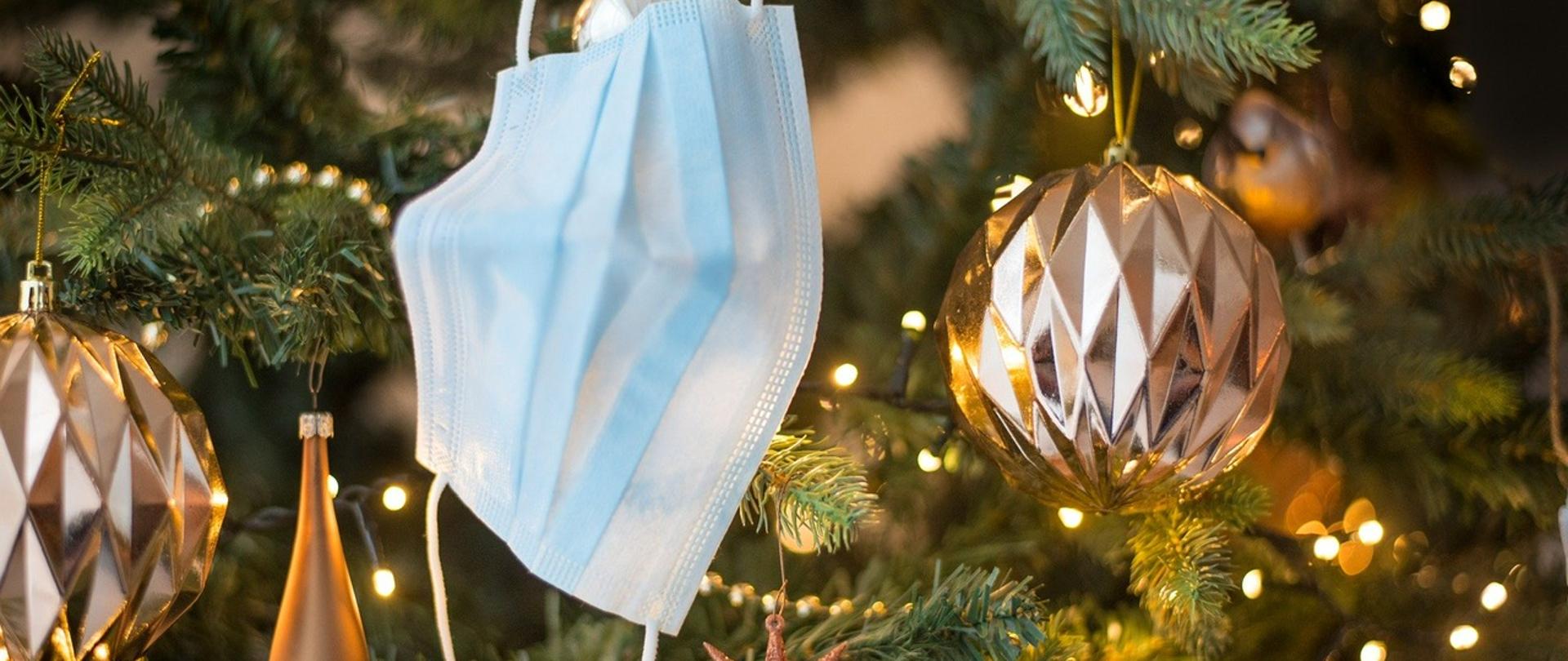 maseczka na twarz jednorazowa zawieszona na świątecznej choince z bombkami