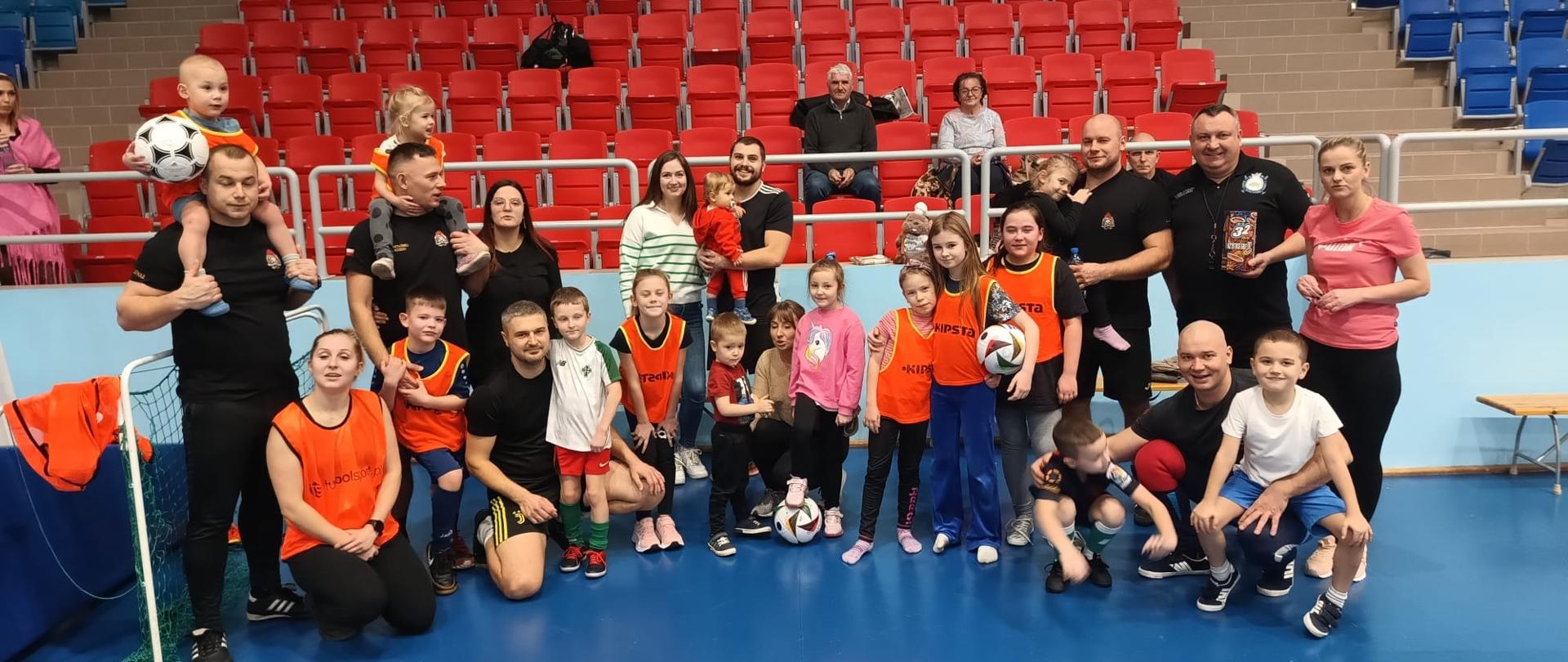 Zdjęcie przedstawia zdjęcie grupowe strażaków z rodzinami podczas Rodzinny Turniej Piłki Nożnej Gramy dla WOŚP! 