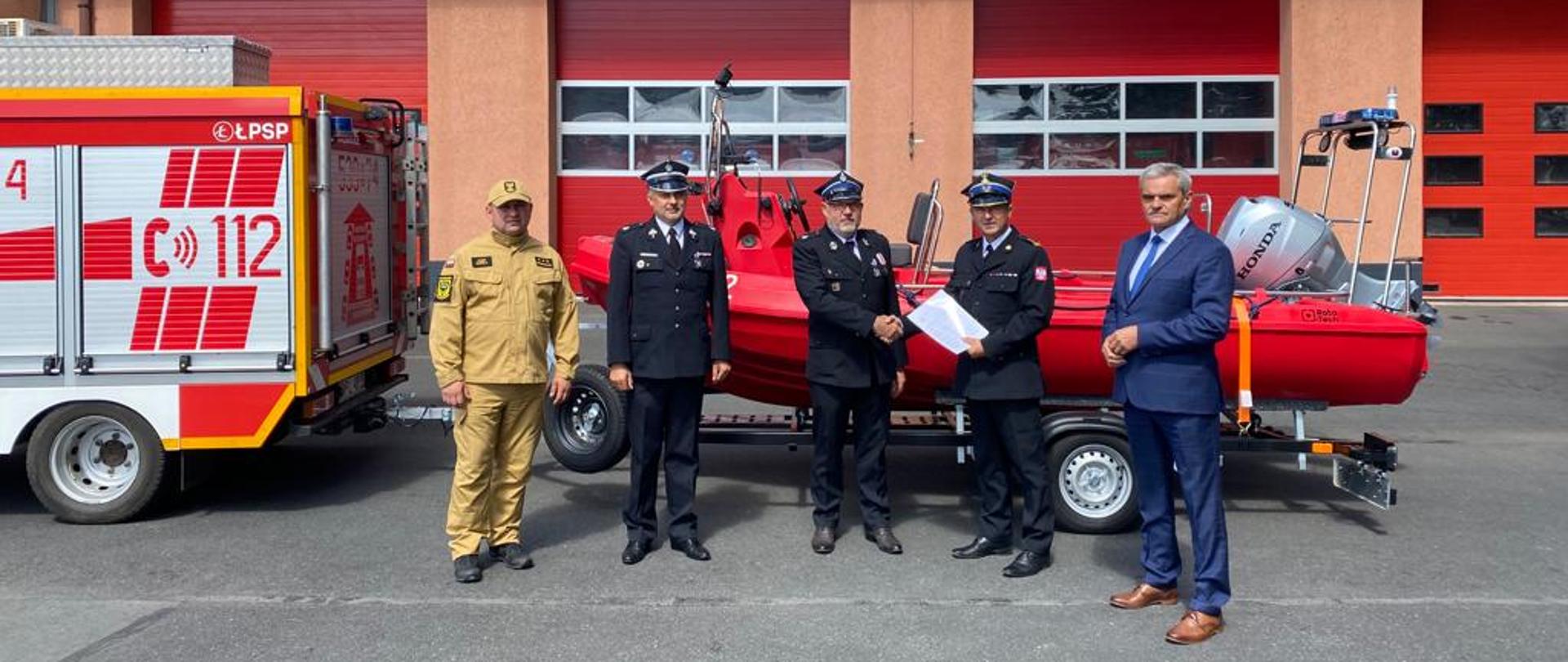 Zdjęcie przedstawia Komendanta Powiatowego PSP, Wójta Gminy Grębocice oraz Strażaków i Druhów OSP na tle z nowoczesną łodzią ratowniczą 