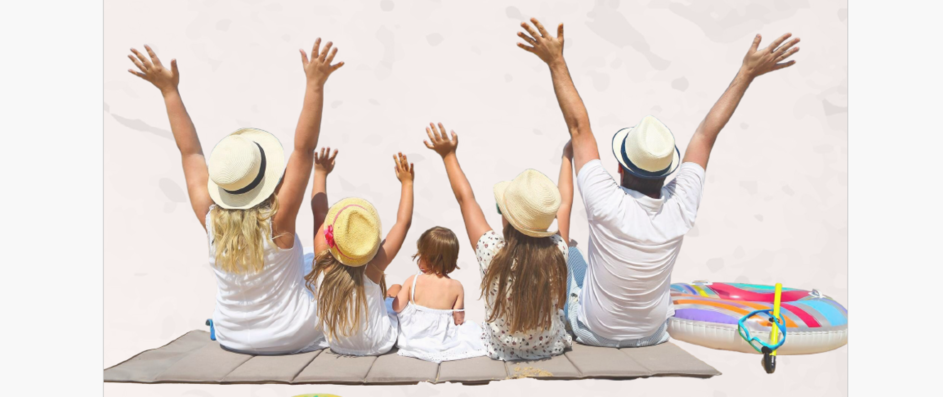 Rodzice z trójką dzieci siedzący tyłem na kocu i trzymający ręce w górze