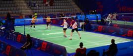 Zdjęcie przedstawia zawodników podczas meczu w badmintona w hali jaskółka