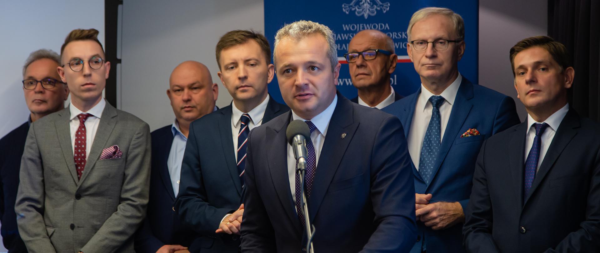 Ośmiu mężczyzn podczas konferencji prasowej