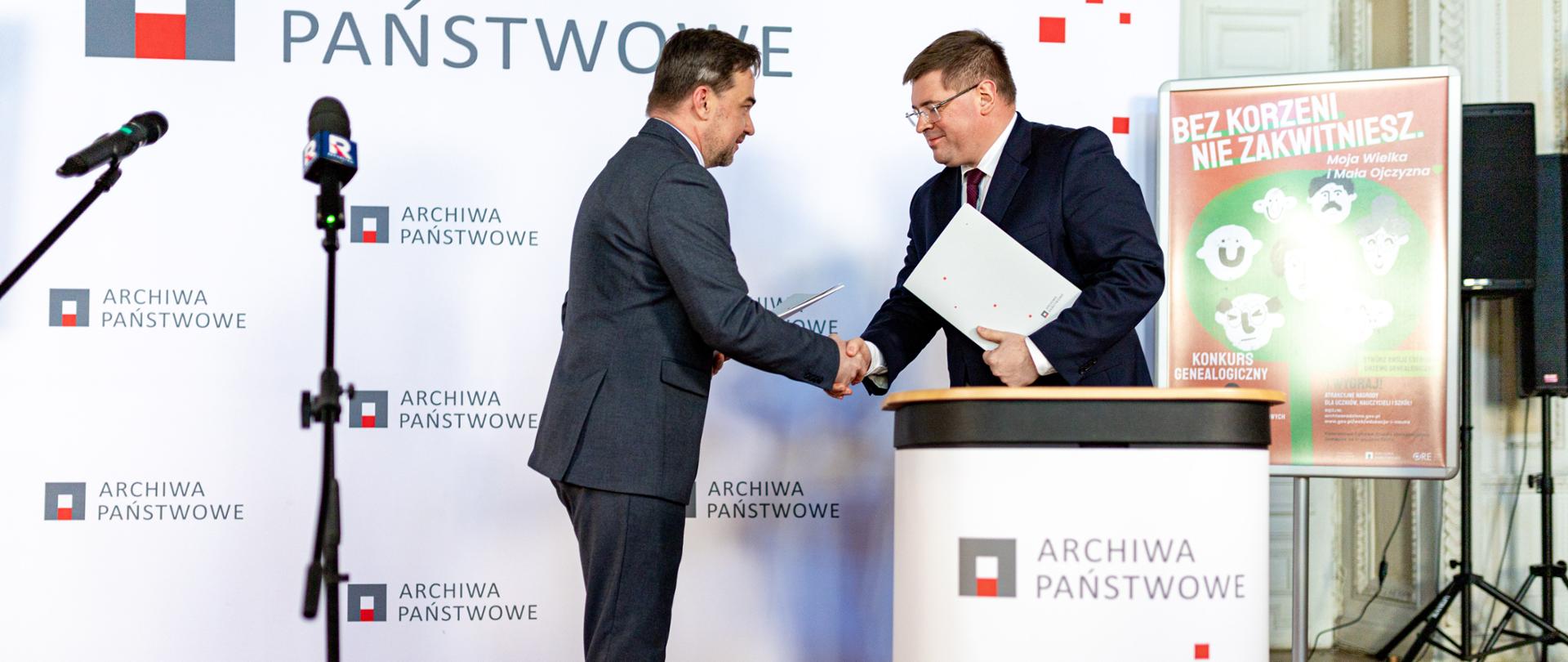 Rusza konkurs „Bez korzeni nie zakwitniesz. Moja Wielka i Mała Ojczyzna”, wiceminister Tomasz Rzymkowski po podpisaniu porozumienia gratuluje przedstawicielowi Archiwów Państwowych.