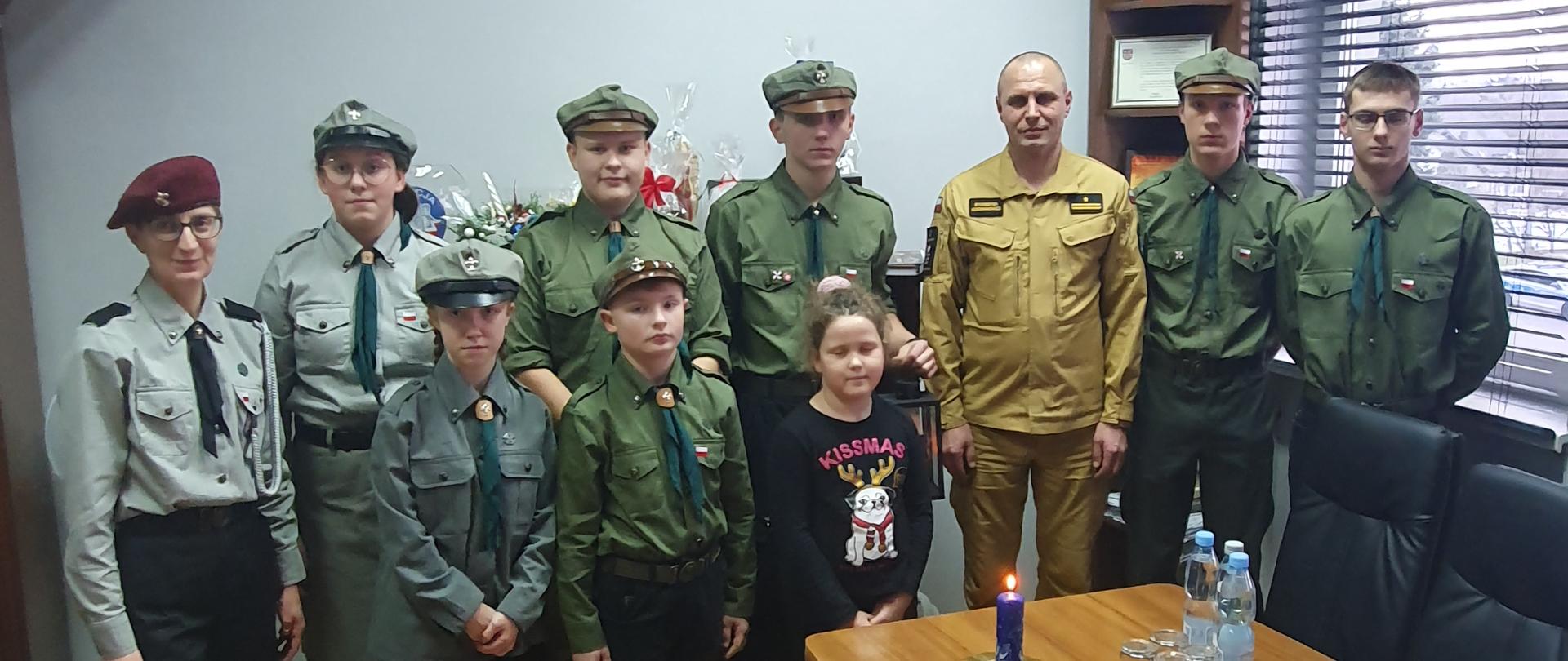 Na zdjęciu grupa harcerzy z komendantem KP PSP Opatów wraz ze światełkiem betlejemskim. 