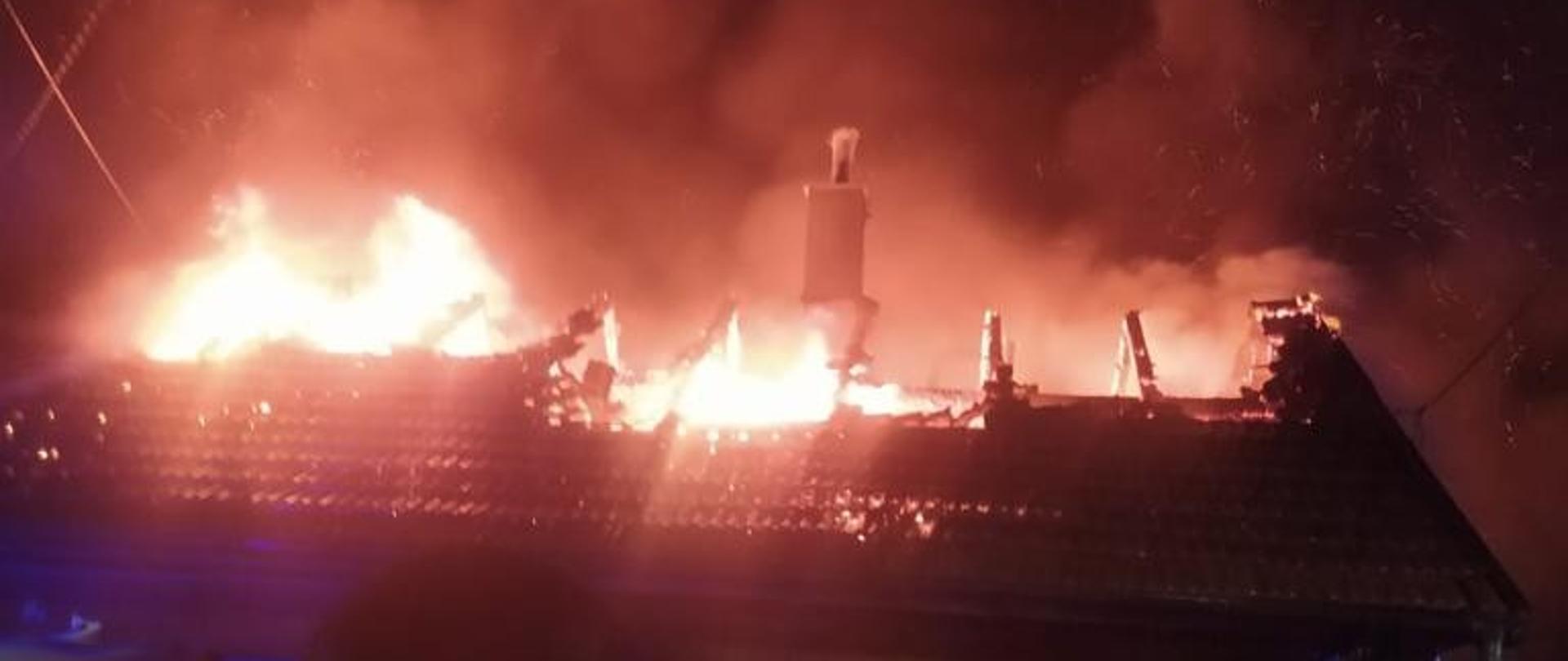 Płomienie wydobywające się z poddasza budynku