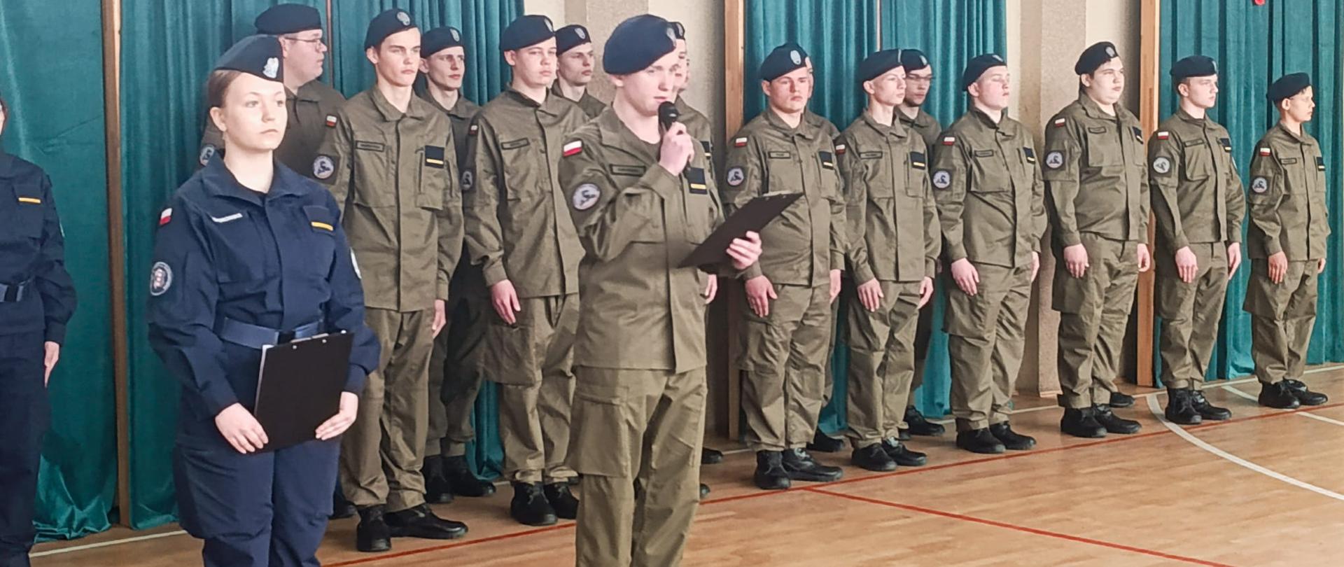 Uczniowie, Dyrekcja szkoły, grono pedagogiczne oraz zaproszeni goście podczas uroczystości zaprzysiężenia klas pierwszych.