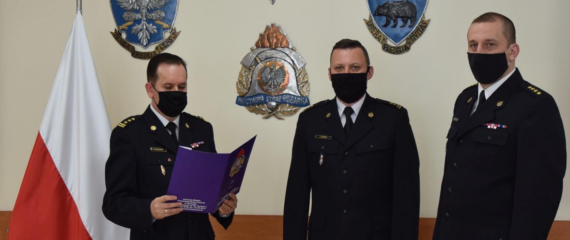 Na zdjęciu komendant miejski PSP w Przemyślu wraz ze swoim zastępcą odczytuje podziękowanie za długoletnią służbę naczelnikowi wydziału operacyjnego