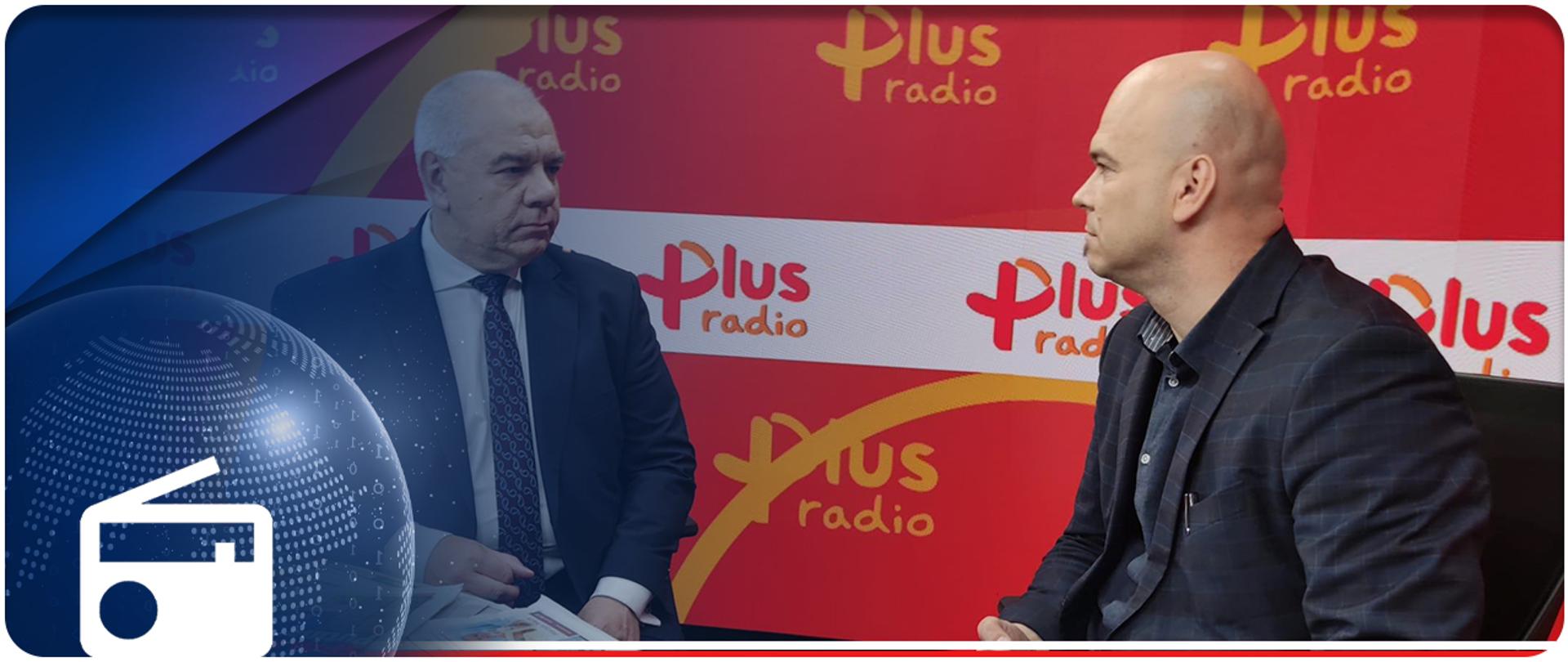 Wicepremier Jacek Sasin i redaktor Jacek Prusinowski siedzą przy stole w studiu radiowym. W tle ścianka z logotypami Radio Plus. W lewym dolnym rogu ikonka radia. 