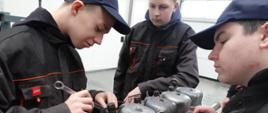 Uczniowie klasy 3BB Płecha Dawid oraz Tomasz Stasiak i Adrian Janiec w czasie montażu wtryskiwacza w ciągniku Ursus c-360 podczas zajęć praktycznych.