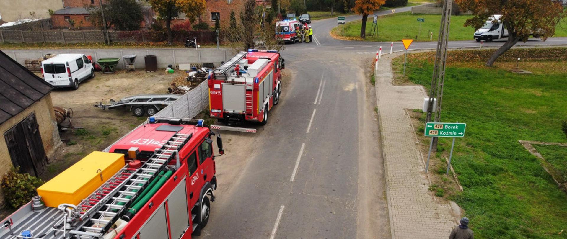 Samochody pożarnicze stoją na drodze.