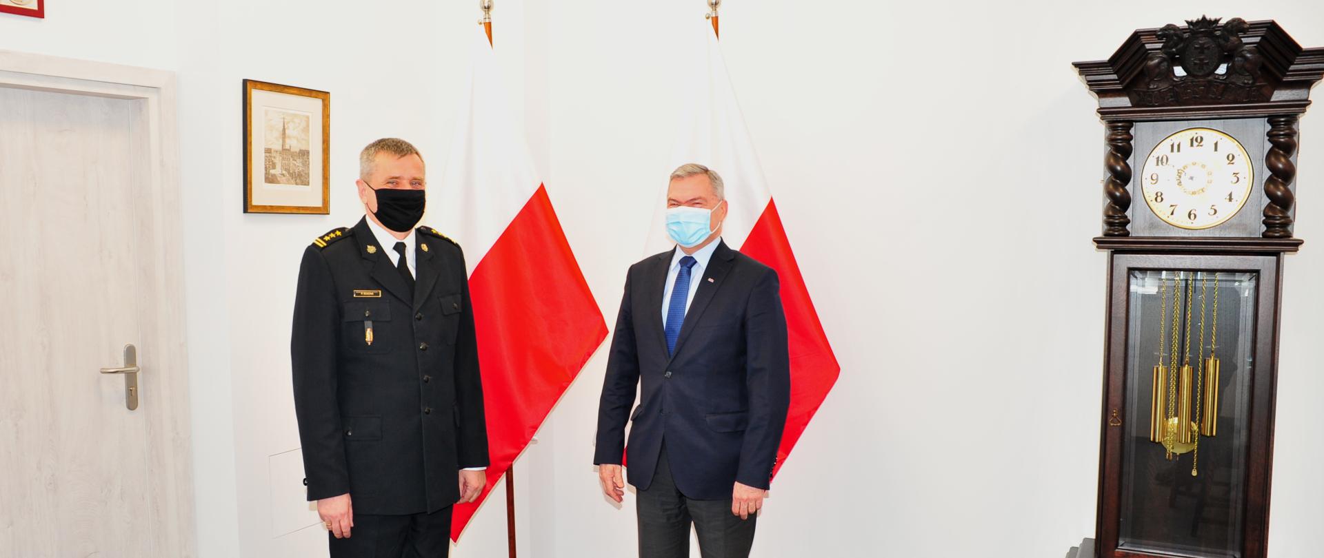 Pomorski komendant wojewódzki PSP wspólnie z przewodniczącym Zarządu Regionu Gdańskiego NSZZ "Solidarność" stoi na tle flagi Rzeczypospolitej Polskiej.