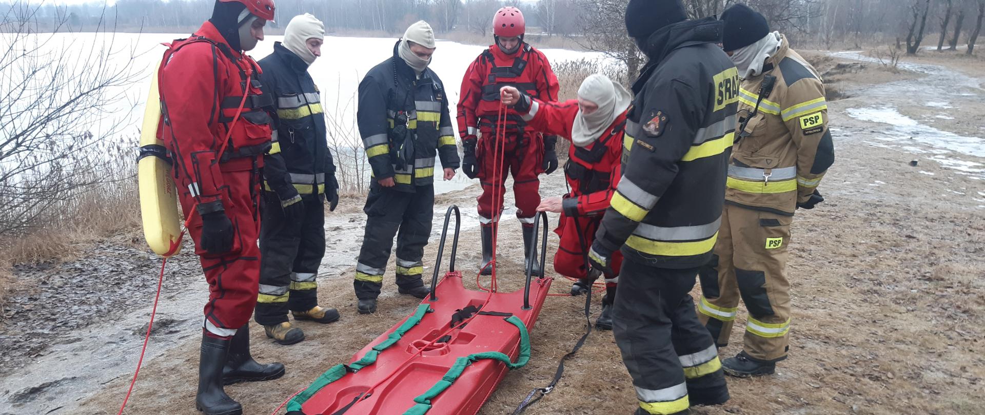 strażacy podczas przygotowania do ćwiczeń przy ssaniach lodowych