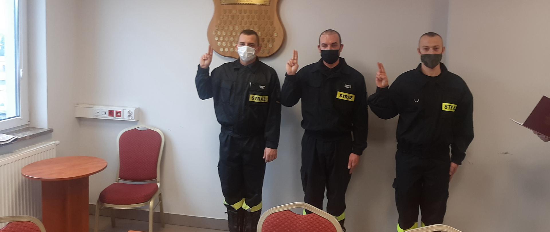Fotografia przedstawiająca nowo zatrudnionych strażaków w sali konferencyjnej KP PSP Szydłowiec podczas uroczystego ślubowania 