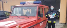 Druh OSP Wielka Wieś przez strażnicą z ulotką
