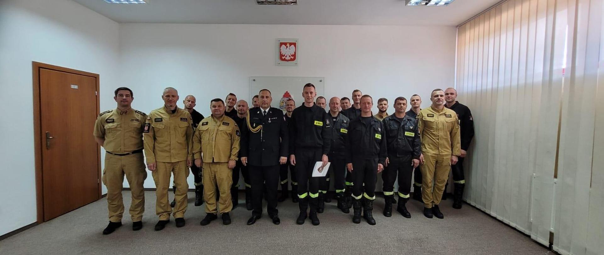 Zdjęcie funkcjonariusz zmiany przyjmującej oraz zdającej wraz z funkcjonariuszami systemu 8 godzinnego po złożeniu ślubowania przez str. Daniela Regulskiego i odznaczeniu kpt. Krzysztofa Zegarskiego. 