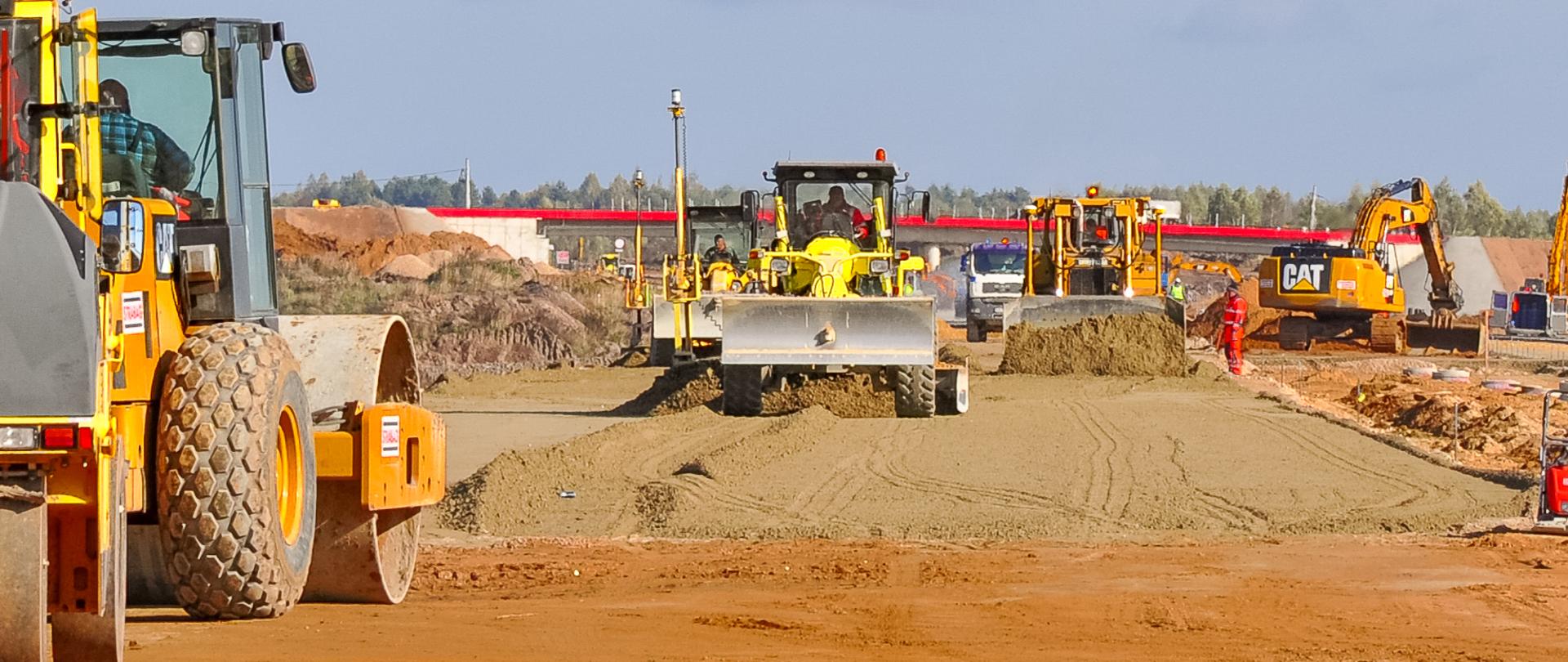 Na zdjęciu widać ciężki sprzęt podczas budowy drogi.