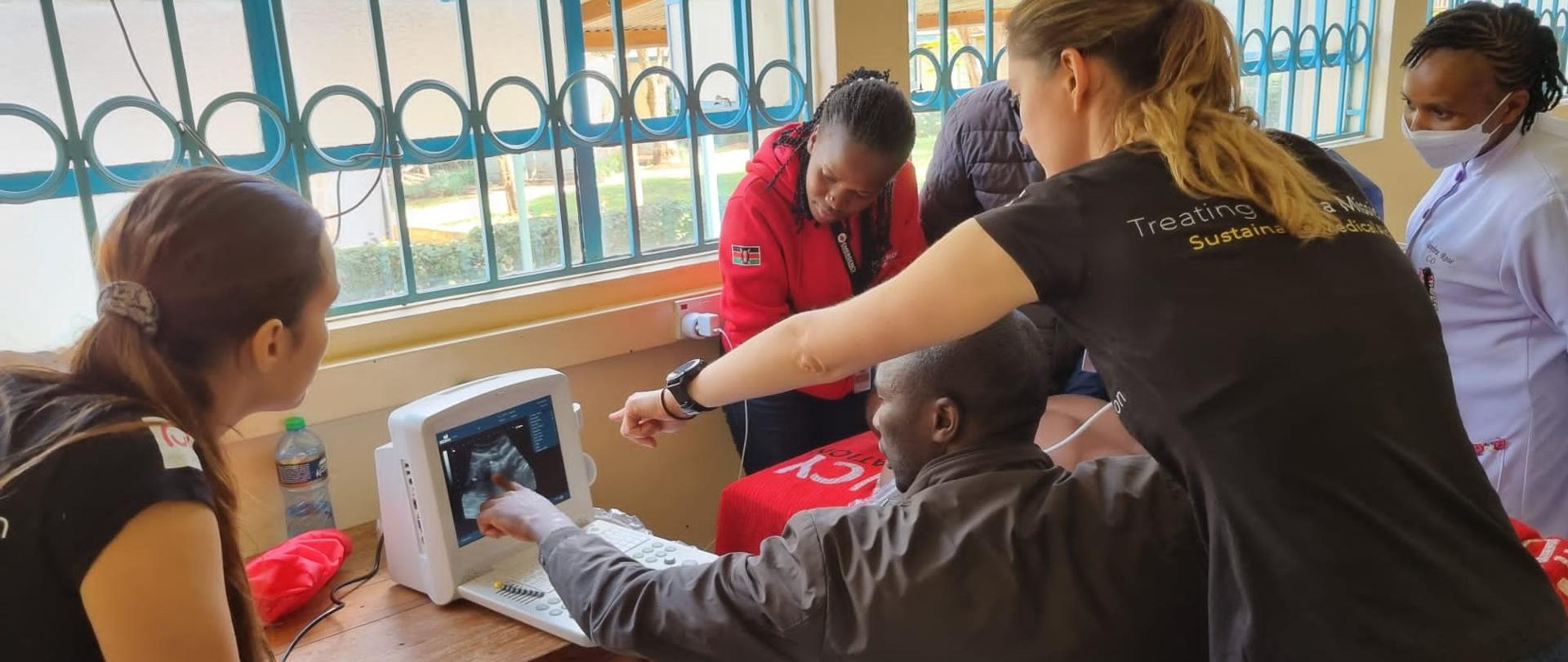 Grupa osób patrzy na monitor od USG