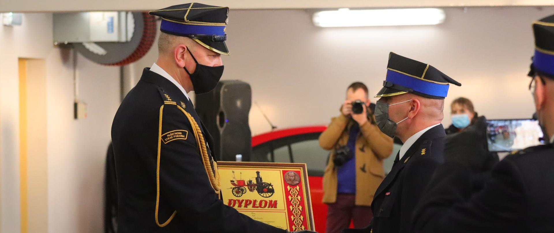 Zastępca Kujawsko Pomorskiego Komendanta Wojewódzkiego PSP wręcza Dyplom Komendanta Głównego PSP funkcjonariuszowi KP PSP Inowrocław.