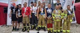 Zdjęcie przedstawia zawodników stojących na podium z flagami swoich państw w zawodach w Kołobrzegu