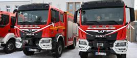 Dwa pojazdy ratowniczo - gaśnicze MAN ze wstążkami czekają na nowych właścicieli