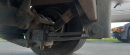 Uszkodzony amortyzator na pierwszej osi przyczepy ciężarowej.