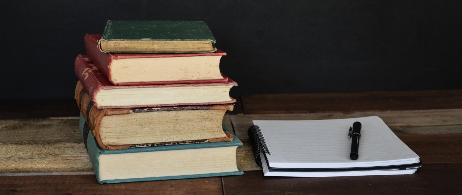 Zdjęcie - książki leżące na drewnianym blacie.